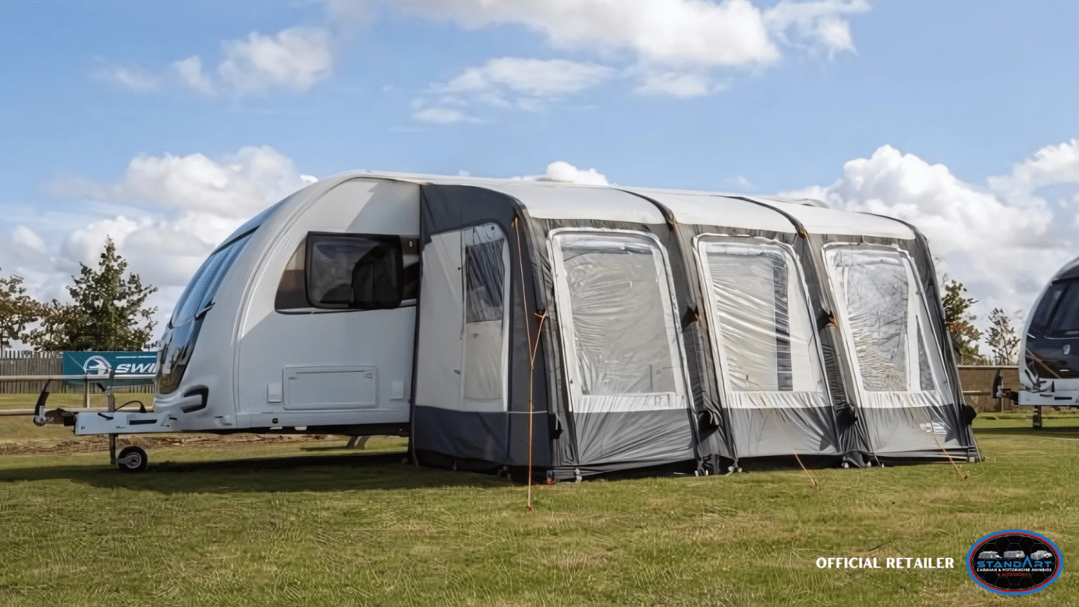 A tent is pitched in the grass near some trees.